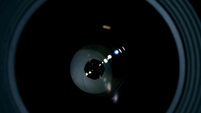 macro shot of a professional video camera while it's lens is zooming. Camera Lens. Internal objective lens of a camera. light swipe through the lens.