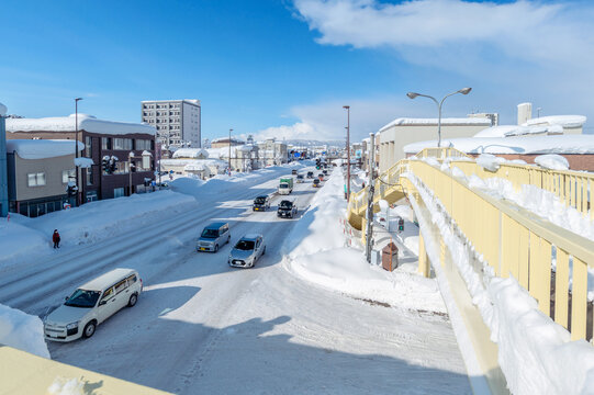 雪国の生活：長かった寒波もようやく終わり、雪がやみ青空が出現。雪道は渋滞発生中。歩道橋から見た風景。