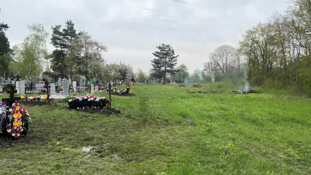 Funeral rite on the country gravesite: pyre, tombs, graves and wet swampy soil after spring rain. Commemoration