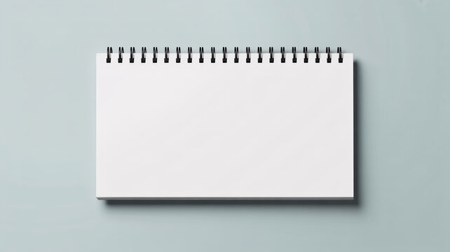 A blank spiral notebook on a light blue background with empty pages ready for writing