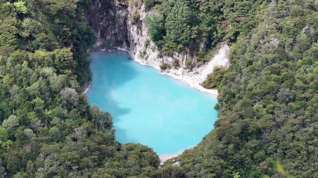 Counterclockwise drone orbit of turquoise crater lake in Waimangu Volcanic Valley New Zealand, stunning nature with geothermal landscape,