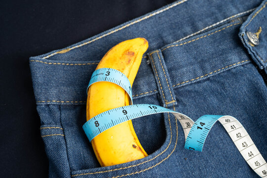 Banana with measuring tape on jean trousers, penis health.