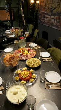 Vertical 9:16 video of a Christmas dinner featuring gourmet steak tartare, artisan cheese platter, and traditional salad for a festive holiday celebration.