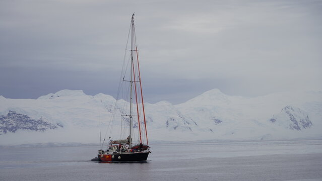 The two-masted schooner Amazone sails through the calm, glacial waters of Paradise Bay, Antarctica, acting as the support vessel for the Fedor Konyukhov solo mission