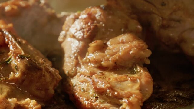 Lamb meat is arranged on a tray with herbs and seasonings before it is placed in the oven. The meat is ready to be cooked for a delicious meal.