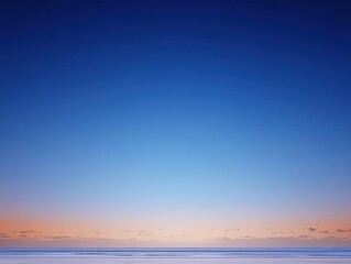 Obraz premium Pastel dawn colors cover the horizon above the ocean surface as day breaks over the water in a quiet moment of morning light