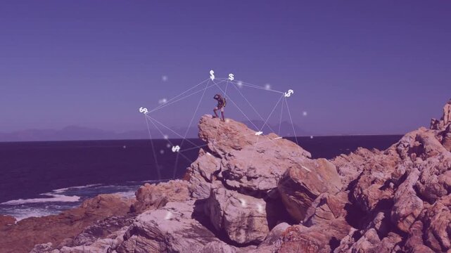 After clip hiker adjusting stance on rock while fintech web forming around him showing currency