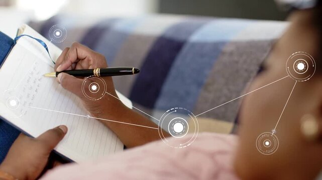 Woman positioning pen, writing on notebook, activating HUD nodes aligning with pen for tech notes
