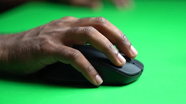 Hand using computer mouse on green.