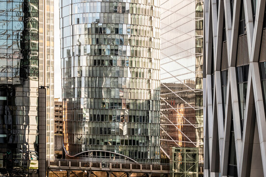 Golden sunset over modern architecture as glass office skyscraper building facade reflection in Paris France creates warm glow dramatic geometry and sharp lines with depth