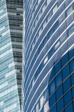 Abstract angle of modern architecture showing glass office skyscraper building facade reflection in Paris France with strong diagonal pattern clean lines and blue tones