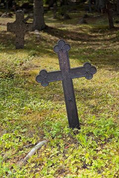 Old, weathered cast-iron grave cross in an old cemetery, Muhu, Estonia, Europe.