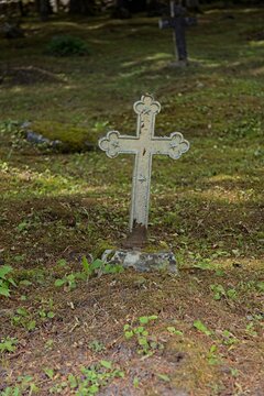 Old, weathered cast-iron grave cross in an old cemetery, Muhu, Estonia, Europe.