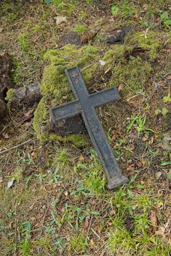 Old, weathered cast-iron grave cross in an old cemetery, Muhu, Estonia, Europe.