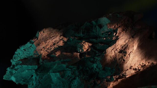 Wide shot rock formation with moving light and green tones