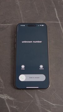 Vertical Screen: A smartphone is on a table showing an incoming call from an unknown number. The screen displays the call options for answering or rejecting the call.