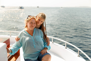 Fototapeta premium Family portrait of mature woman and girl on boat trip