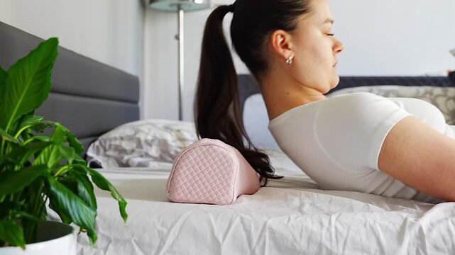 Woman lying on ergonomic orthopedic pillow on bed. Demonstrating cervical spine support, proper neck alignment and comfortable sleep for posture correction and pain relief at home.