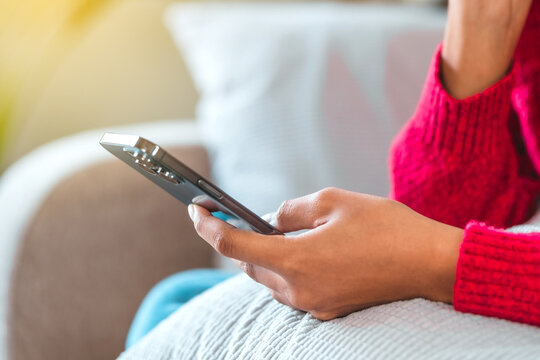 Teenage women sitting on sofa listening to music enjoying meditation for sleep and peaceful mind in wireless headphones relax at home