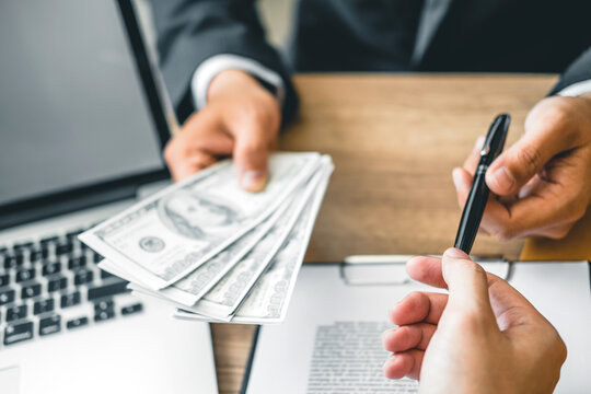 Corruption concept,Business man passing money dollar bills corruption bribery to businessman manager