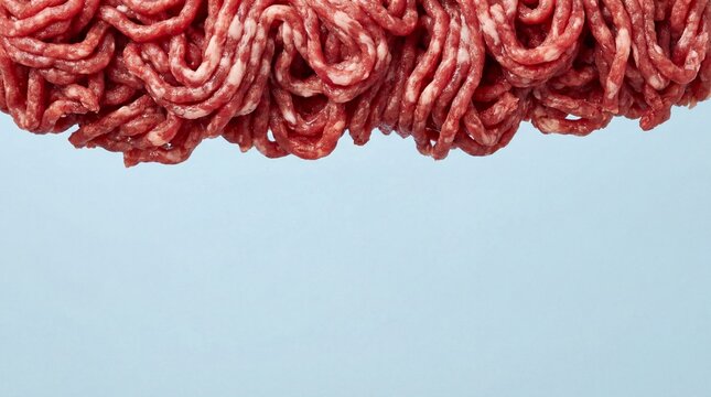 Fresh raw ground beef meat isolated on a light blue background