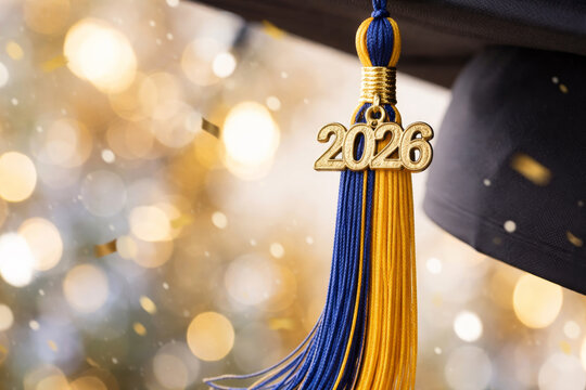 Class of 2026 graduation cap tassel with year charm, confetti and party lights bokeh background.