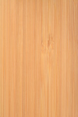 Fototapeta premium A detailed full frame view of a natural bamboo wood surface showing smooth vertical grain lines and a warm light brown color texture