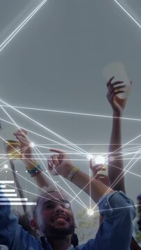 Vertical video: Music crowd dancing to beat, raising hands with cups under grey sky, nodes syncing