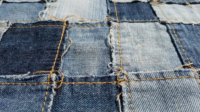 Upcycled patchwork denim fabric texture with stitching details.