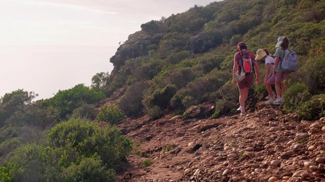 Mother and twin girls hike on trail in Robberg Nature Reserve in Plettenberg Bay