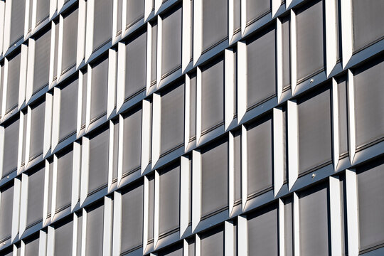 Modern architecture facade of building panels with texture and grid pattern showing repetition and geometry in clean contemporary exterior detail