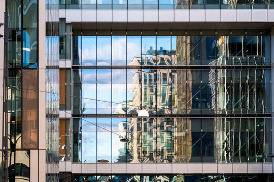 Modern architecture facade detail of glass building with reflection in windows creating pattern and urban symmetry in contemporary office exterior