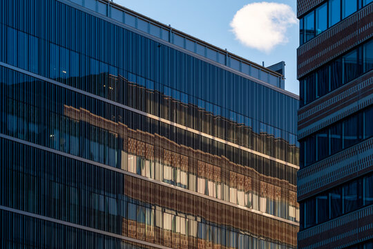 Modern architecture facade of blue glass building with reflection under sky lines creating pattern on contemporary urban exterior detail