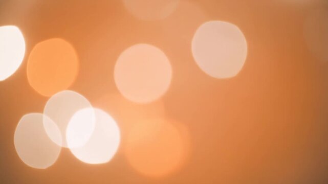 オレンジ背景に浮かぶ柔らかな光抽象テクスチャイメージ