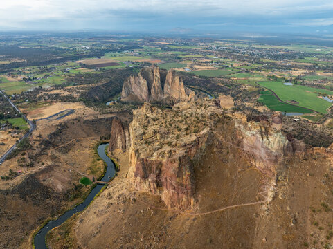Aerial view of Smith Rock State Park featuring towering basalt cliffs and the winding Crooked River through the high desert landscape in Crooked River, Oregon, United States.