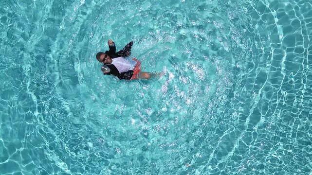 Crazy summer business. Funny business man in suit with laptop jump in swimming pool. Fun business humor. Excited freelancer in summer. Fun business and summer vacation crazy businessman.