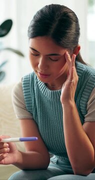 Upset, pregnancy test and woman on sofa in home with regret, stress or mistake for unplanned maternity. Anxiety, scared and female person with positive result for failed birth control in house.