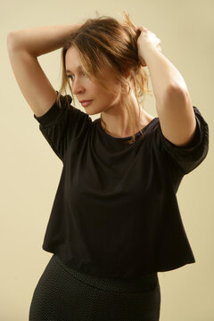 Studio Fashion Portrait of Woman in Black Short Sleeve T-Shirt with Sleeve Details &ndash; Elevated Basic Style