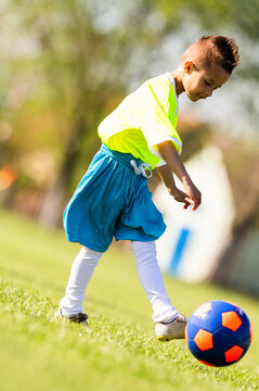 Young boy kicking soccer ball