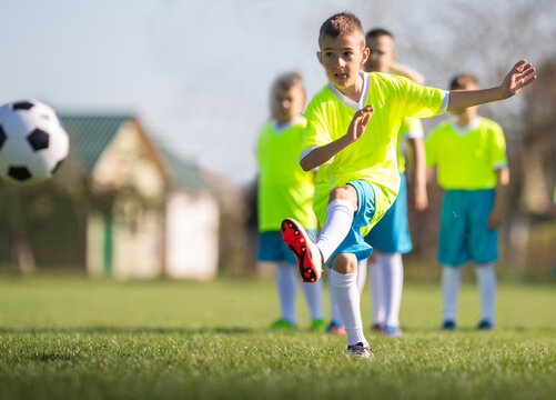 Young boy kicking soccer ball