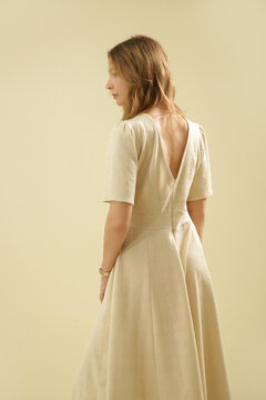 Studio Fashion Portrait of Woman in Beige Midi Short Sleeve Dress on Beige Background