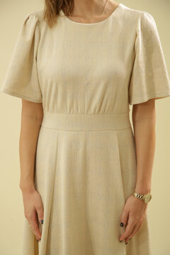 Studio Fashion Portrait of Woman in Beige Midi Short Sleeve Dress on Beige Background