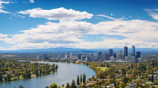 Panoramic view of city skyline across river with green parkland.