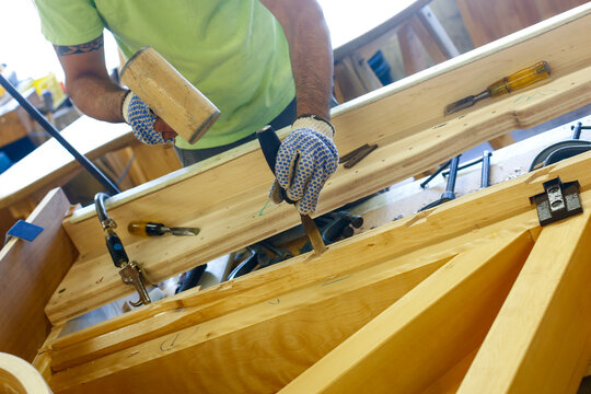 Worker hammering wood in workshop