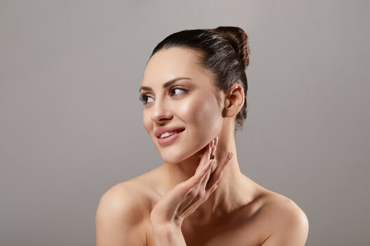 Beautiful woman beauty portrait looking aside touching neck and jawline, female model with smooth healthy glowing skin, natural skincare cosmetology dermatology spa wellness beauty concept
