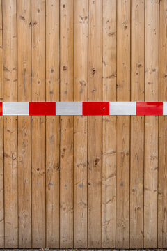 Wood barrier with stripe creates warning blockade on urban street signaling restriction of access and promoting safety for controlled roadway entry
