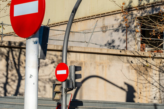 Urban street pole holds sign for prohibited entry and roadway restriction reinforcing circulation safety and regulated traffic movement in the city