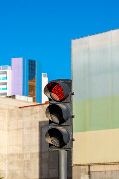 Urban intersection uses red traffic signal light for street roadway control enhancing safety and orderly movement in city transportation networks