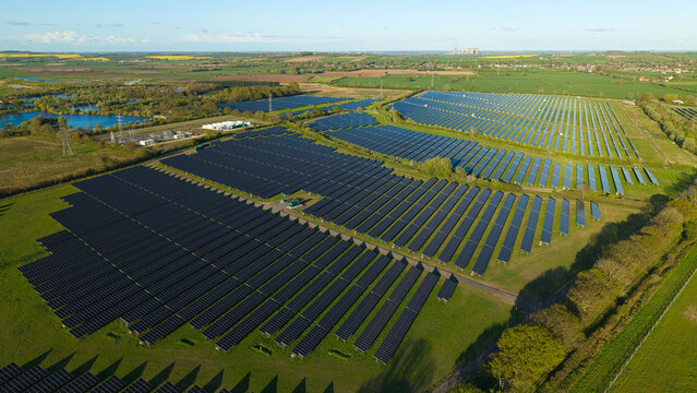 Drone view of the Tiln Farm solar power development and green fields bathed in warm sunset light United Kingdom