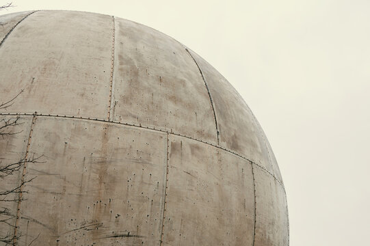 Close Up Weathered Concrete Sphere With Panels, Visible Seam Lines And Subtle Discoloration, Soft Pale Sky
